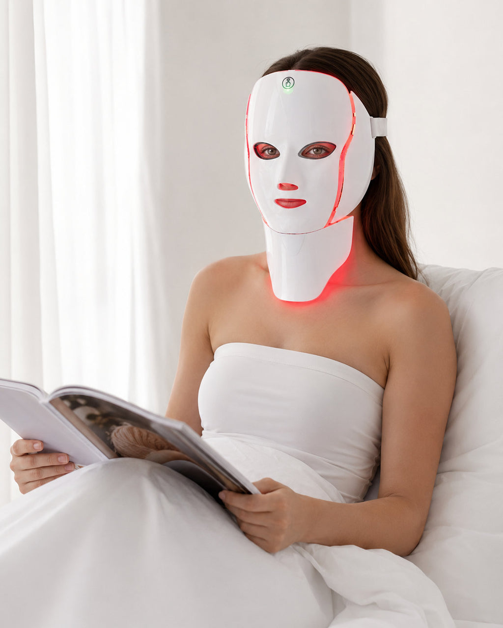 Reading in bed during a ten minute cordless red light therapy session with the LED Longevity Mask